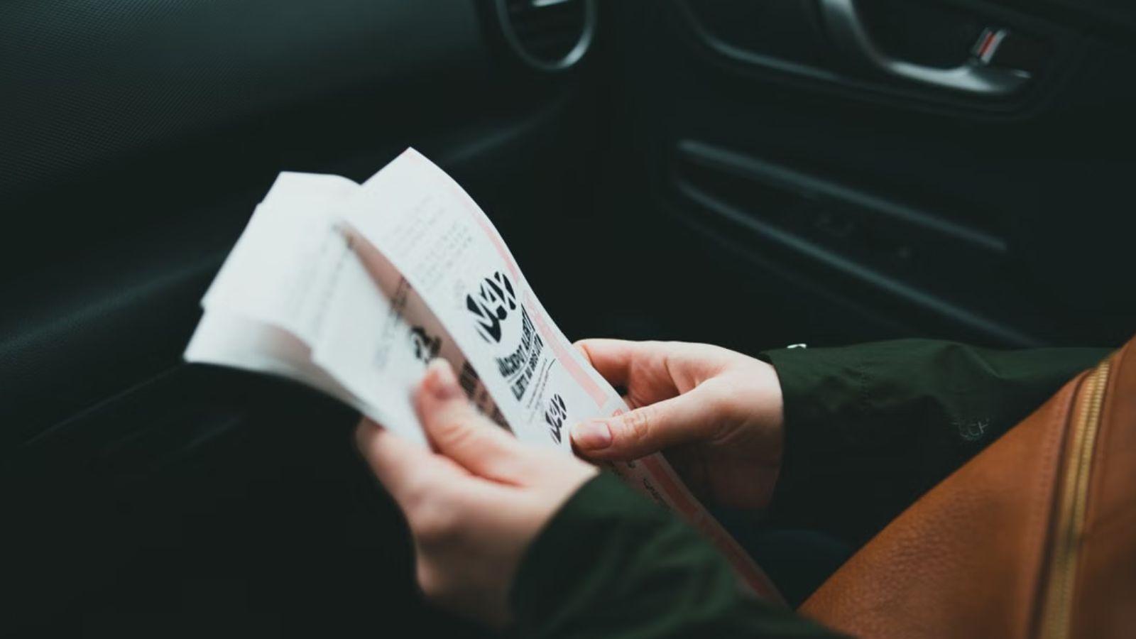 She Accepted a Last Minute Extra Ticket from a Longtime Friend—Then Received a $350 Venmo Request During the Encores Woman holding tickets in her hand while inside the vehicle