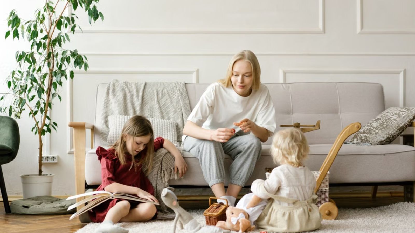 She Rented a Room From Her Aunt to Study and Work — Then Became Their Unofficial, Unpaid Babysitter Woman babysitting two kids who are reading and playing