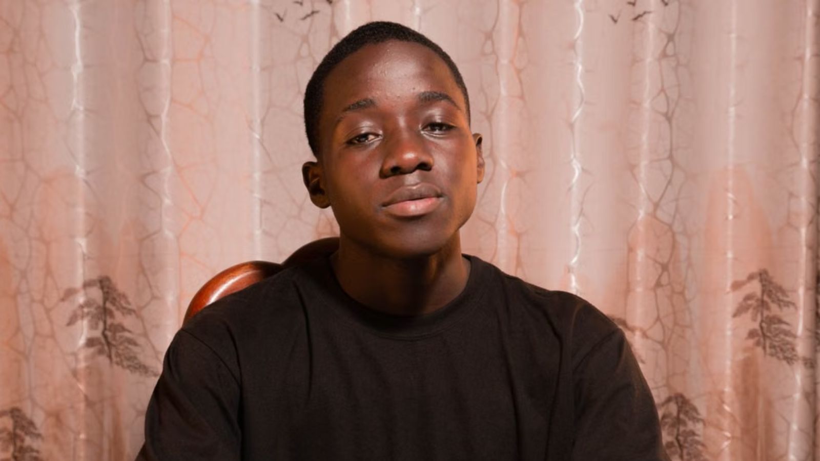 He Overheard Explosive Bigotry at the Dinner Table—Then Quietly Recorded the Conversation to Protect His Own Peace A young man sitting at a table indoors with a neutral background