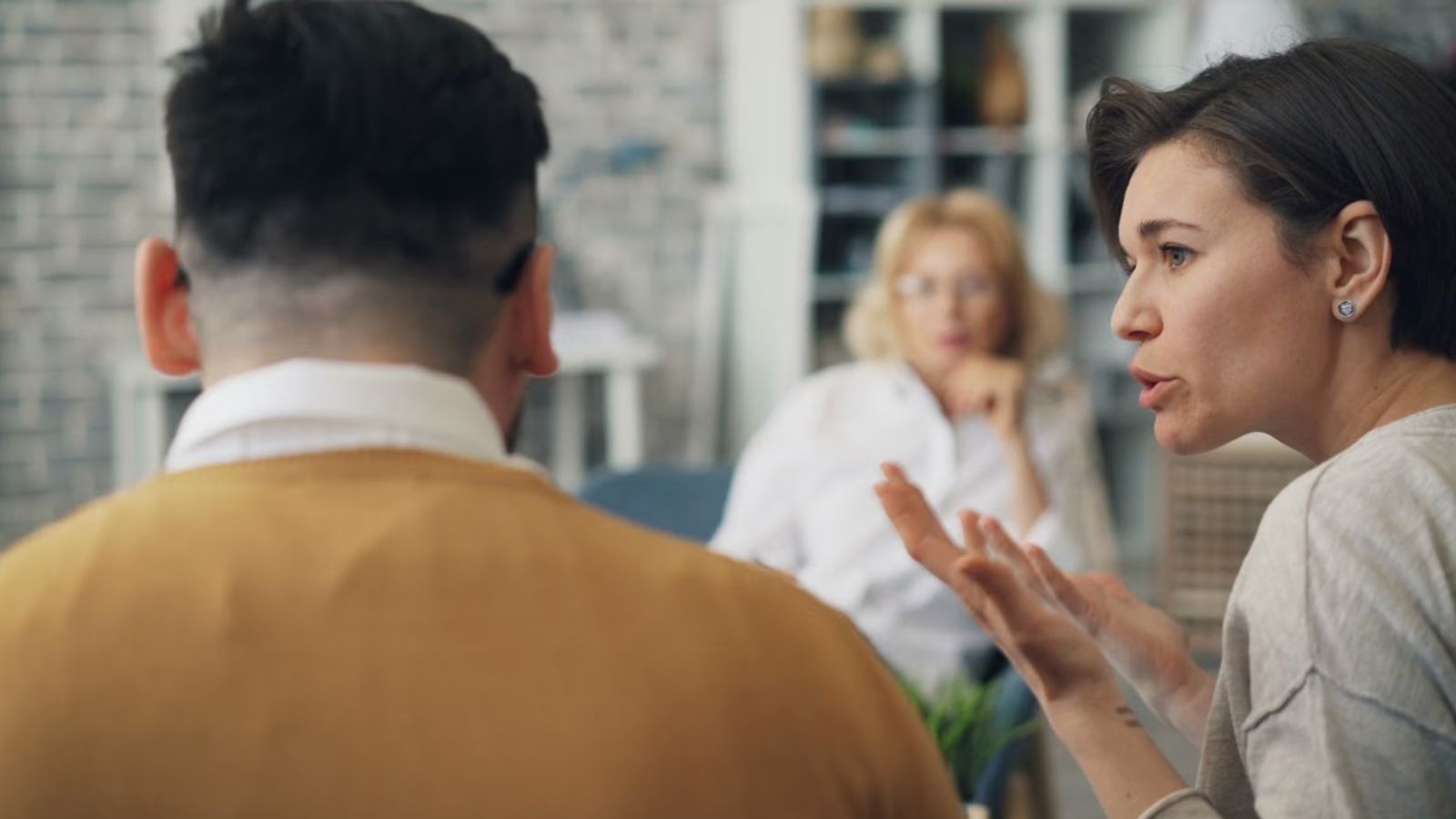 Woman talking to a man while an older lady sits across them