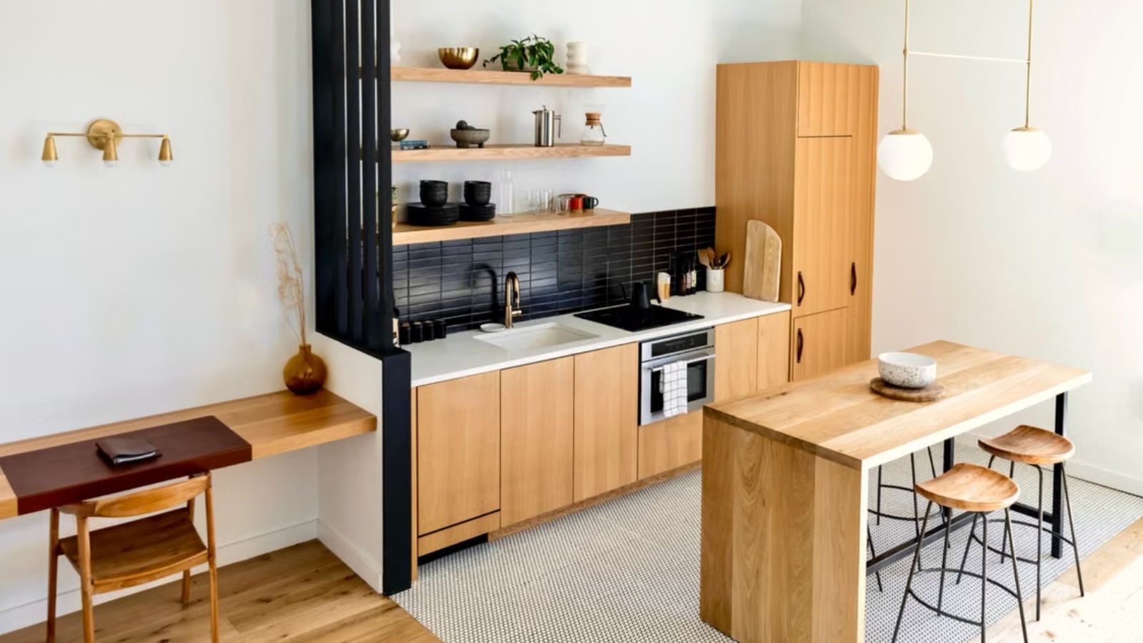 She Found Out the House Next Door Is Becoming an Airbnb — Now Shes Worried About Losing Her Familys Privacy Light-filled modern kitchen interior with wooden furnishings and black accents