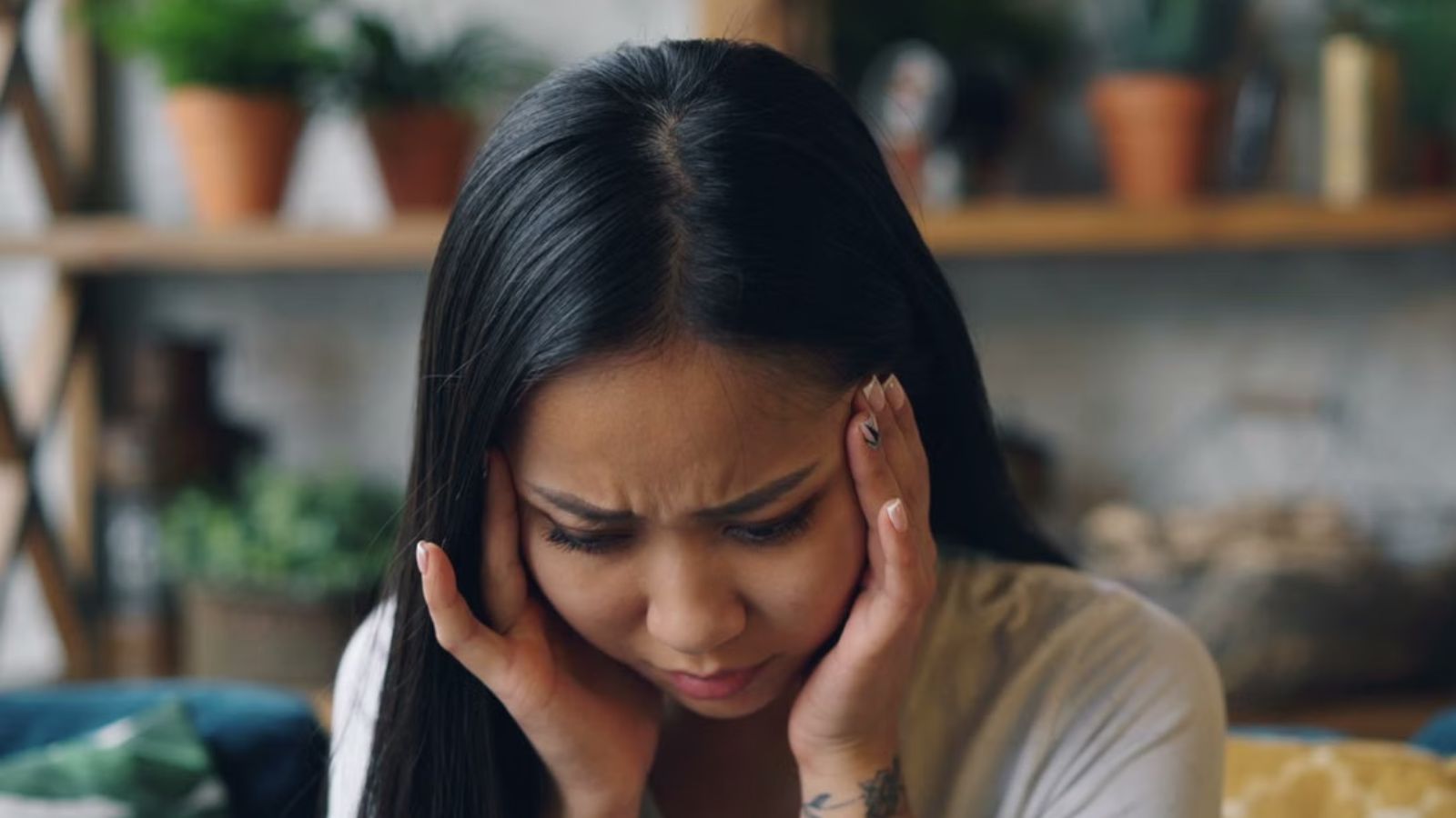 Her Neighbors Kids Scream Every Night — Shes Considering Calling Social Services Over the Noise Woman touching her head feeling strssed and frustrated