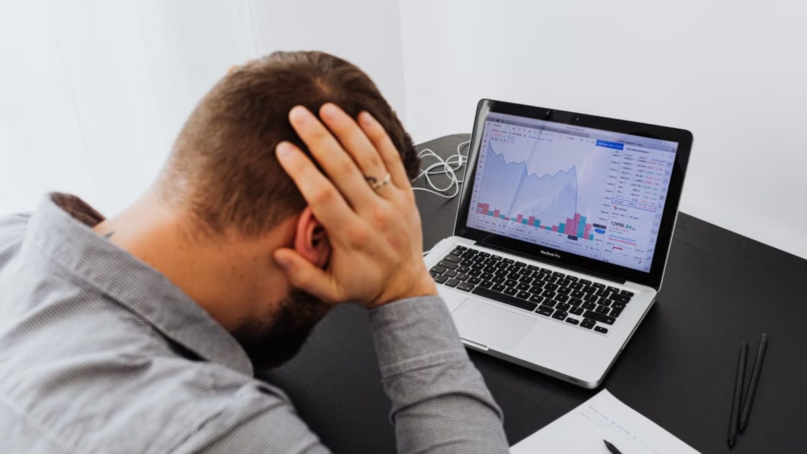 Frustrated worker touching his head in front of his laptop