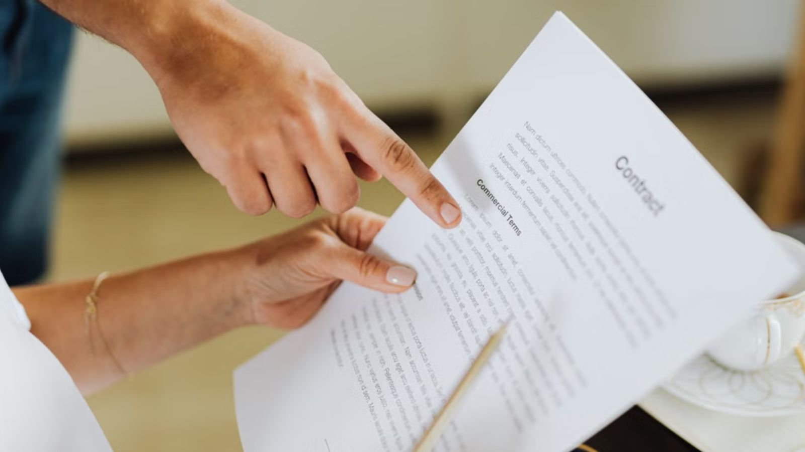 Woman Spent Years In IT, But Finally Left Her Full Time Job After Growing Tired Of Low Pay And Constant Pressure Woman reading a contract while another person points to some lines on the document