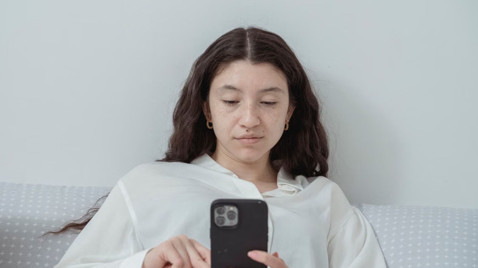 Woman Received An Email From Her Ex After Something Bad Happened To Her Dog, But Quickly Realized It Was AI Generated Woman looking at her phone with a poker face