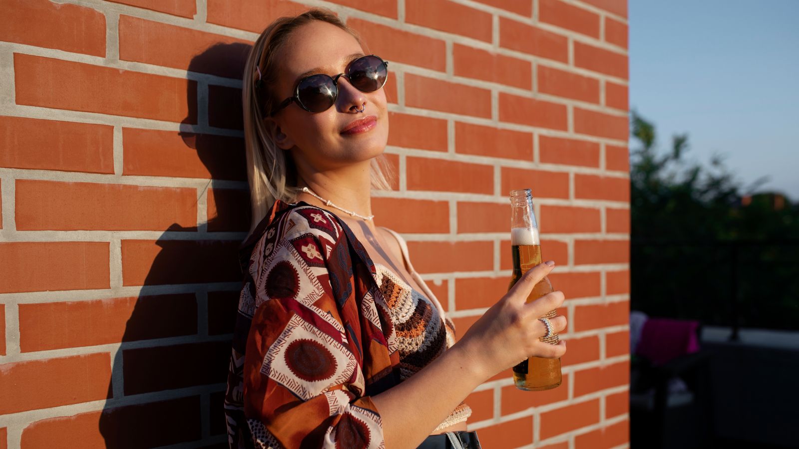 She Politely Declined Her Intoxicated Neighbors Midnight Invitations—Then Woke Up to $3,500 in Manufactured Municipal Code Violations Woman with sunglases holding a bottle of beer