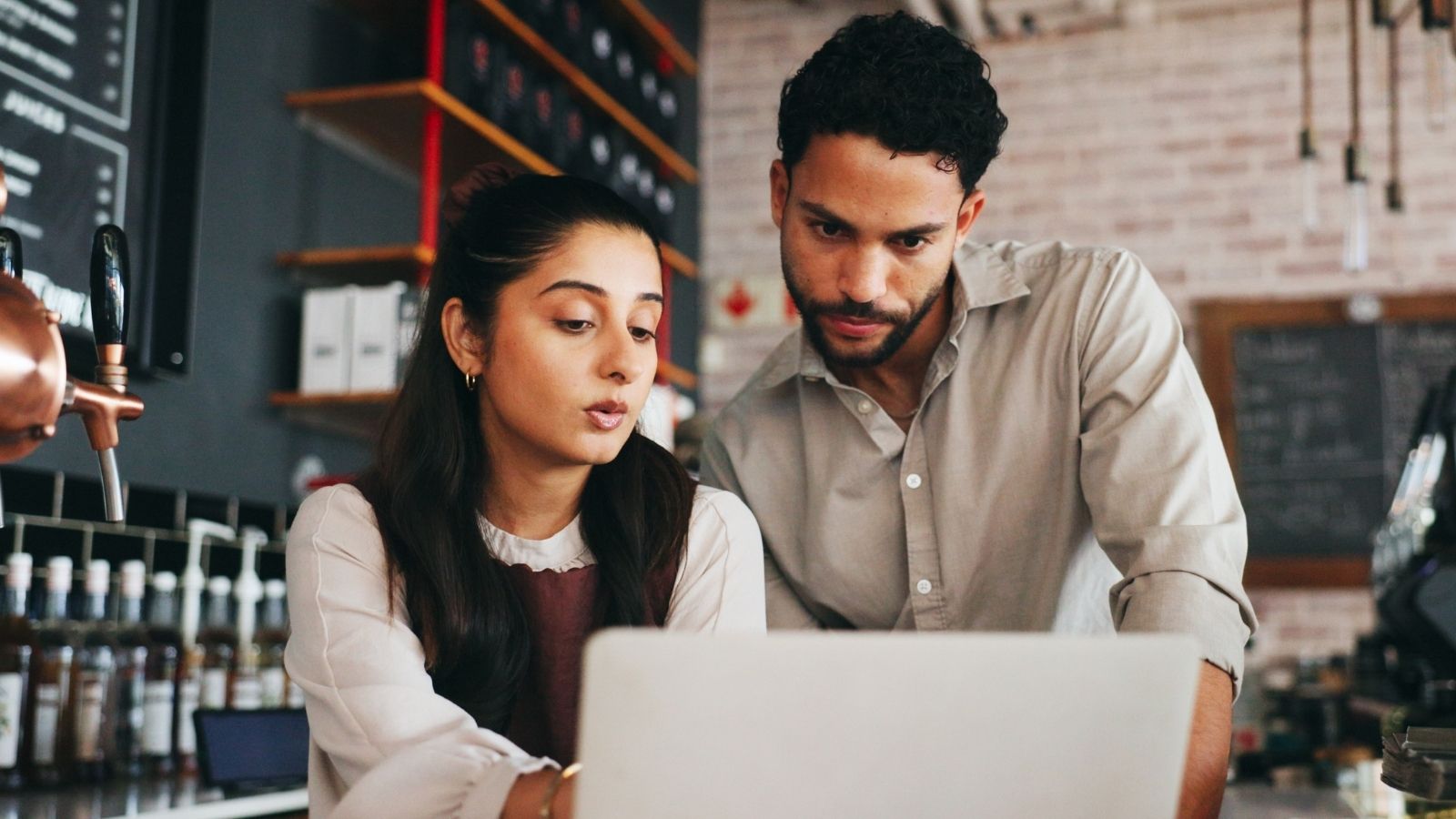 New Cafe Employee Is Confused About How The Manager Splits The Tips Among The Staff, But The Manager Makes Excuses Instead Of Giving A Straight Answer two cafe workers looking at a laptop