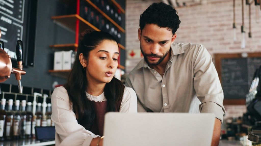 two cafe workers looking at a laptop