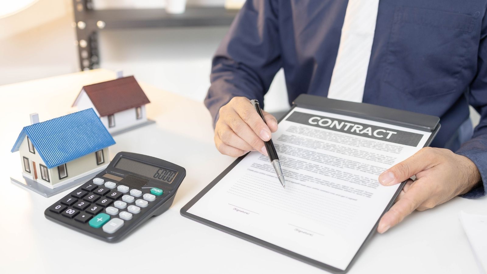 She Found Her Dream Skyline Condo—Then Pulled the HOA Budget and Discovered a Impending $45,000 Special Assessment Trap man using a pen to point out where to sign on a contract