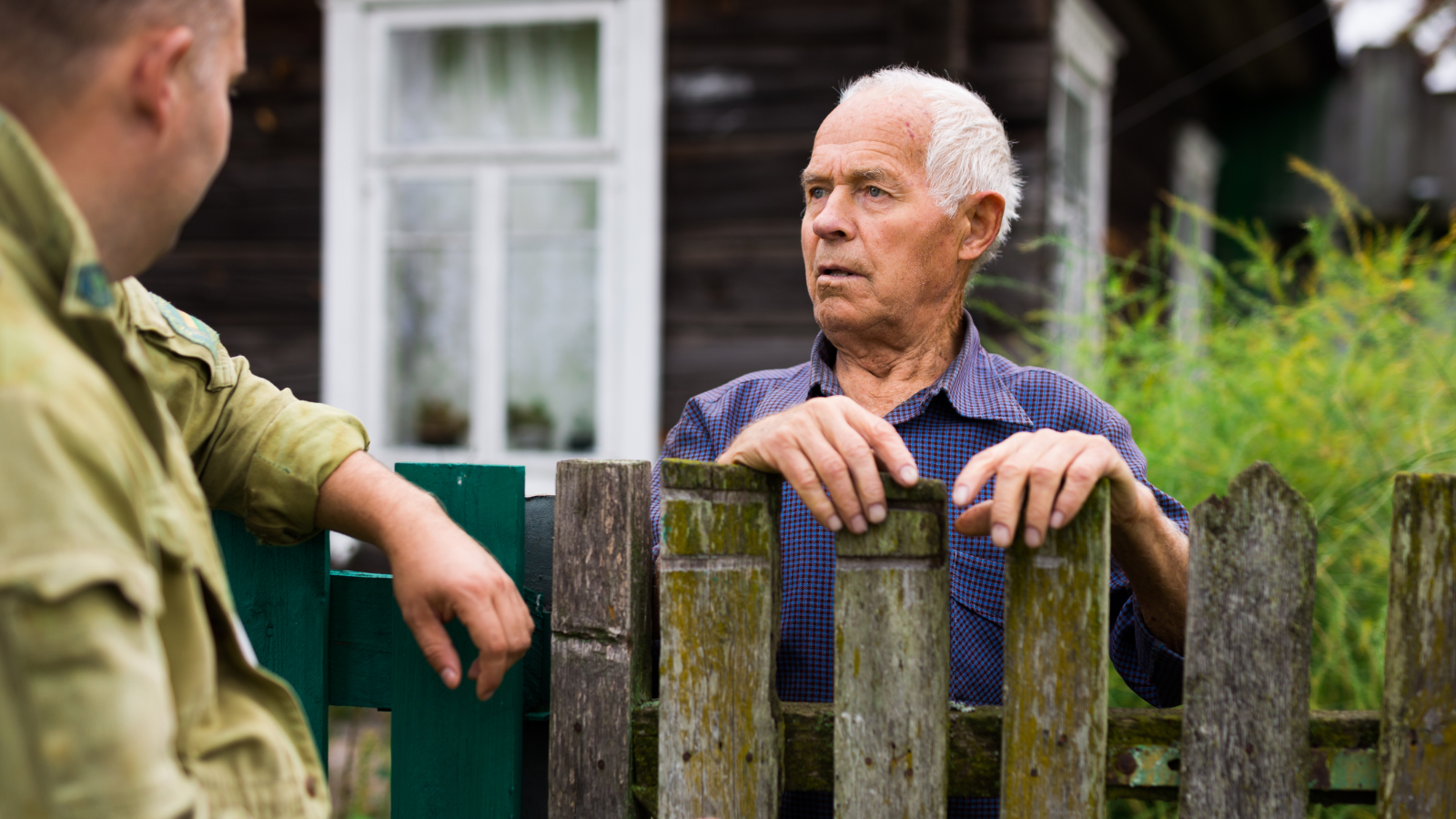 two men talking across a fence