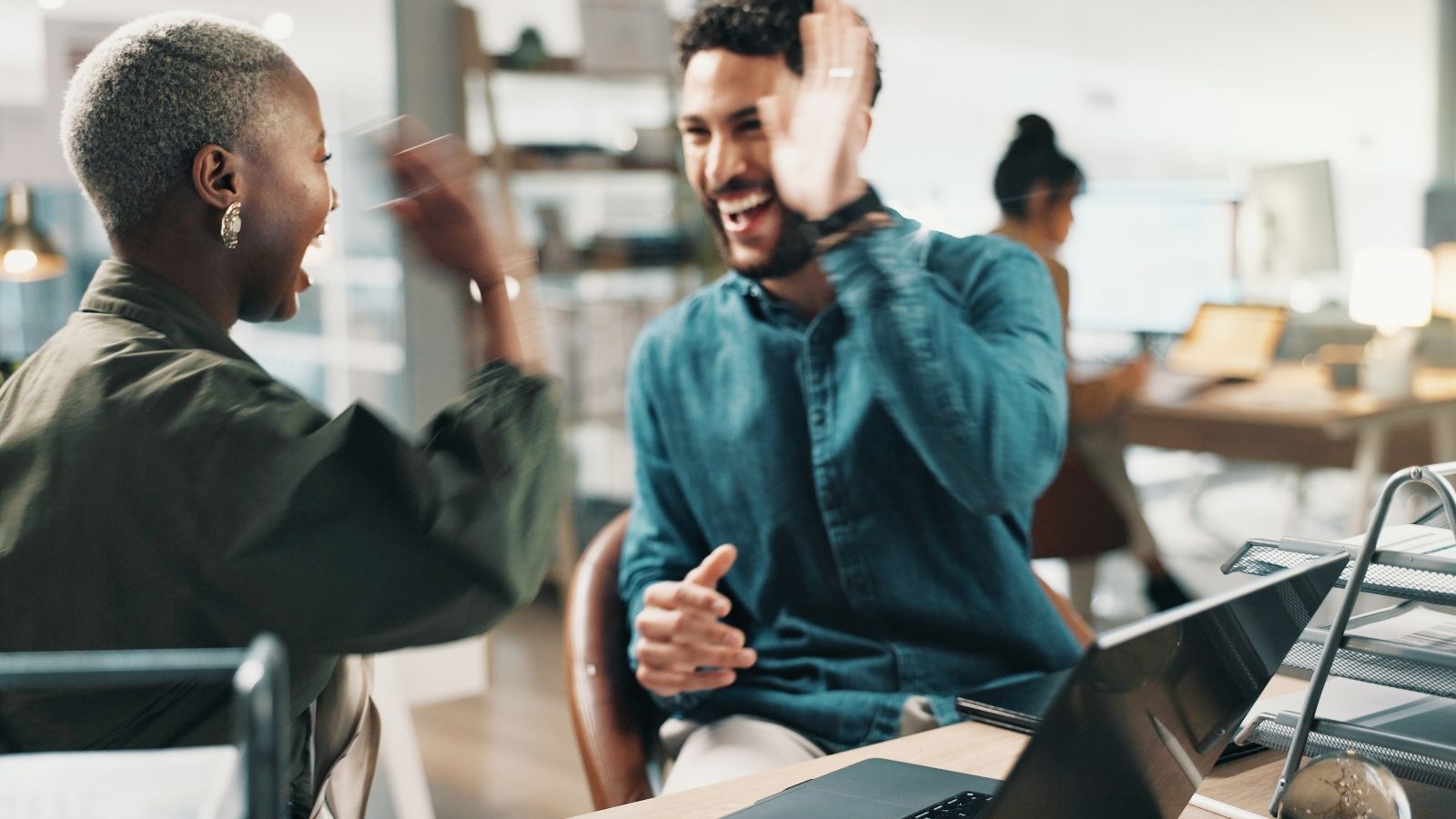 two office workers high fiving