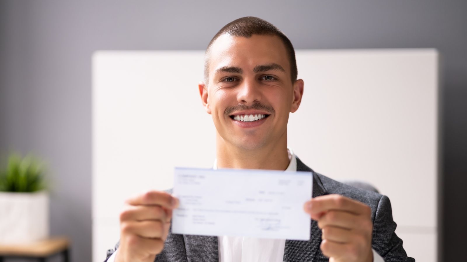 He Sold His Old Car to His Cousins Boyfriend — Then They Broke Up, and the Payments Stopped smiling young man holding a check