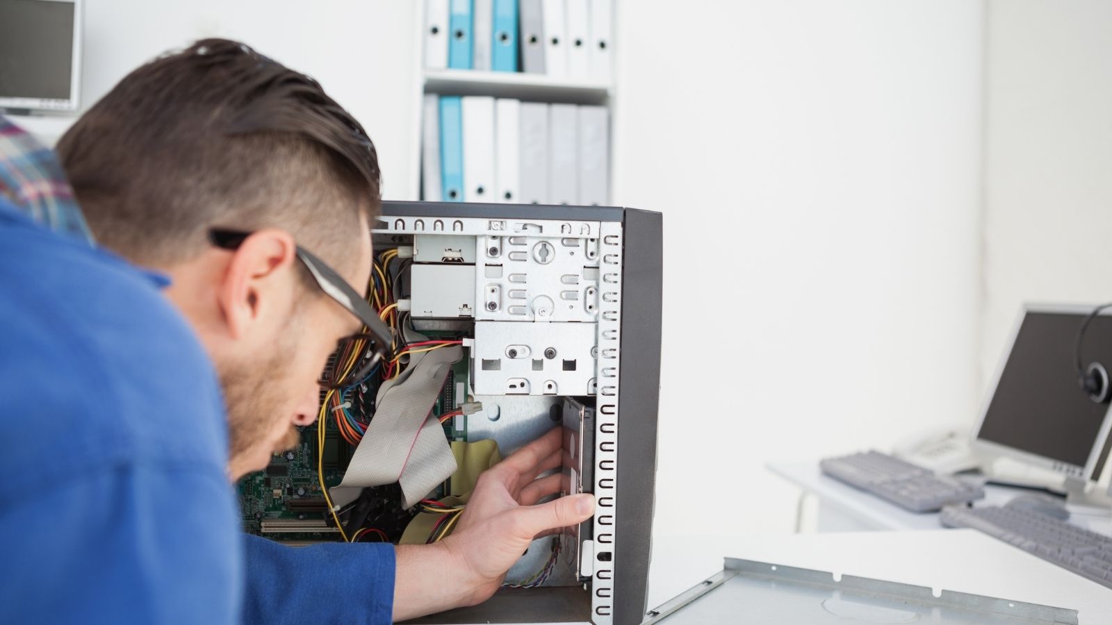 He Was Ordered to Drill Through a Swollen Lithium Ion Battery to Fix an ER Workstation—Then Triggered an OSHA Emergency Audit man fixing a computer