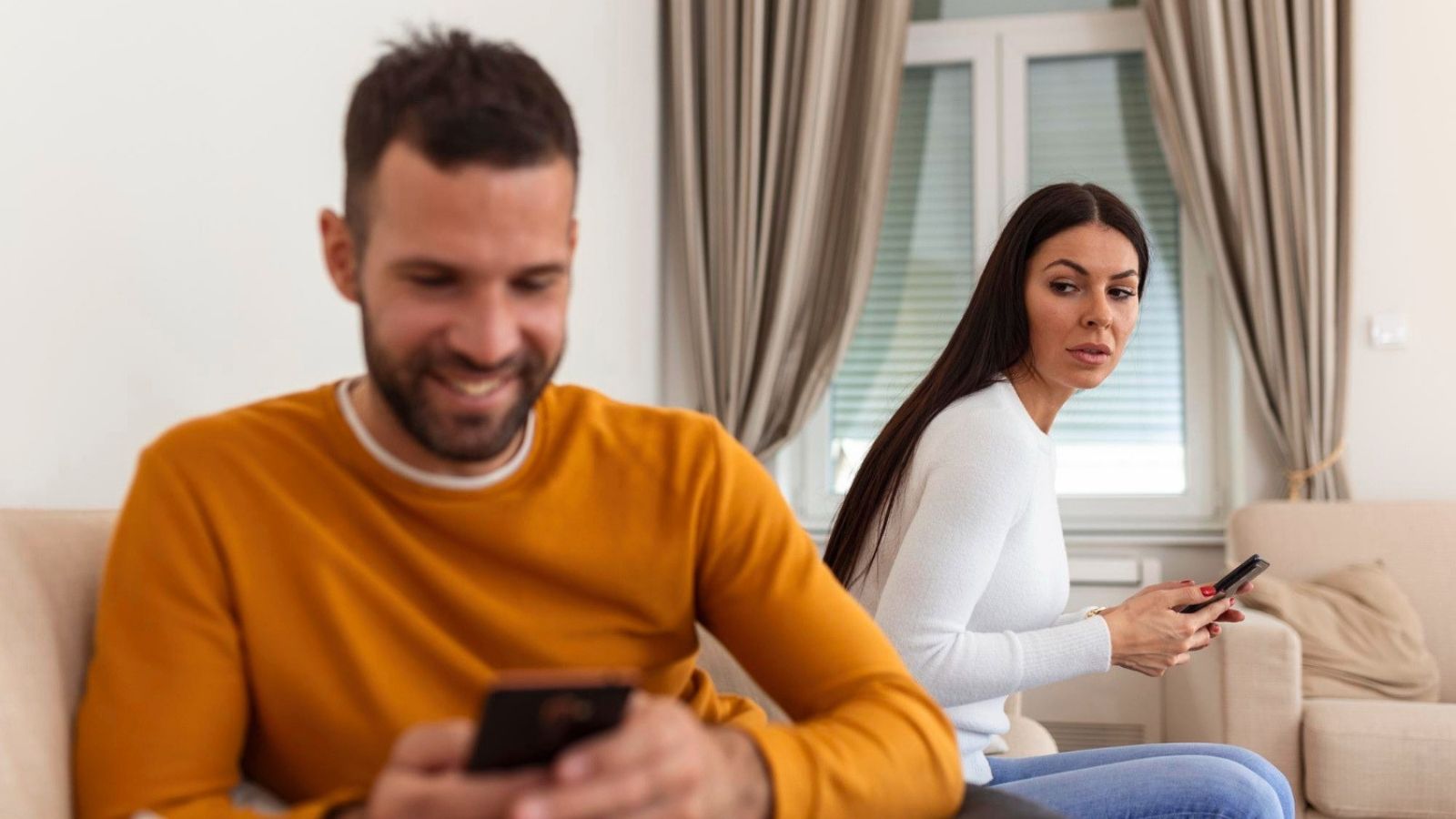 Woman looking at husband using phone