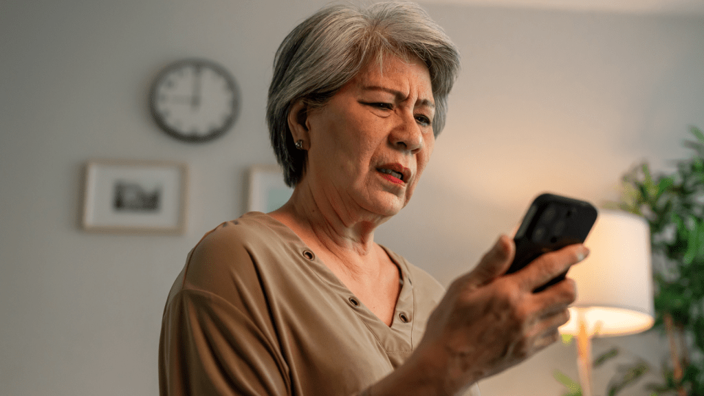 an older woman perplexed looking at phone