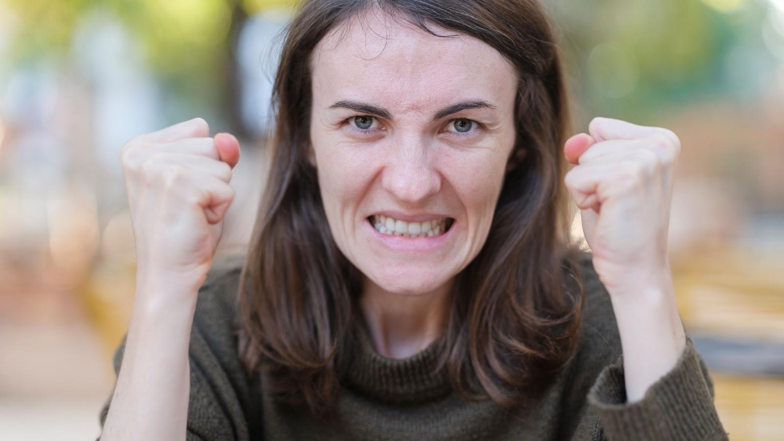 She Kept Her Assigned Parking Spot From A Pushy Neighbor — He Retaliated With Years Of Maintenance Chaos angry woman putting her fists up