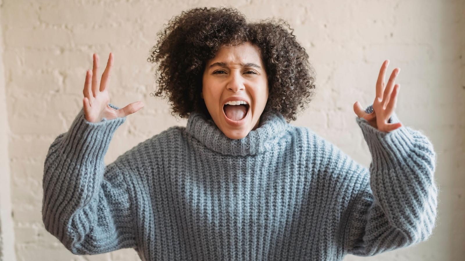 She Paid $600 for Thick Rugs and Underlayment—Then Her Downstairs Neighbor Filed a Noise Complaint While She Was Out of State angry woman putting her hands up