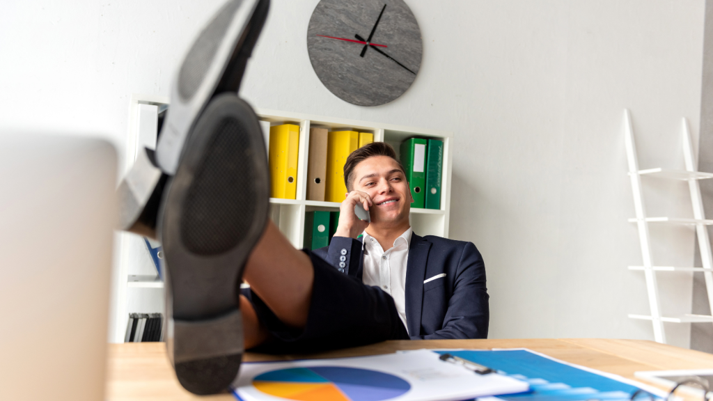 bad boss man with his feet on his desk talking on phone