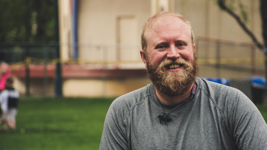 Homeowner Was Fined Over A Tiny Garden Fence, So He Filled His Yard With Hundreds Of Noisy Whirligigs Until His Neighbor Backed Down bearded man smiling outside