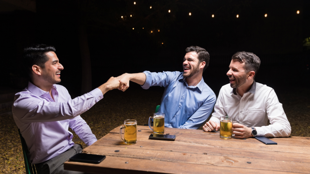 She Expected an Easy Night Out With Friends—Until Hidden Tensions and Entitled Demands Turned the Evening Into a Total Disaster cheerful guys drinking around a table at night