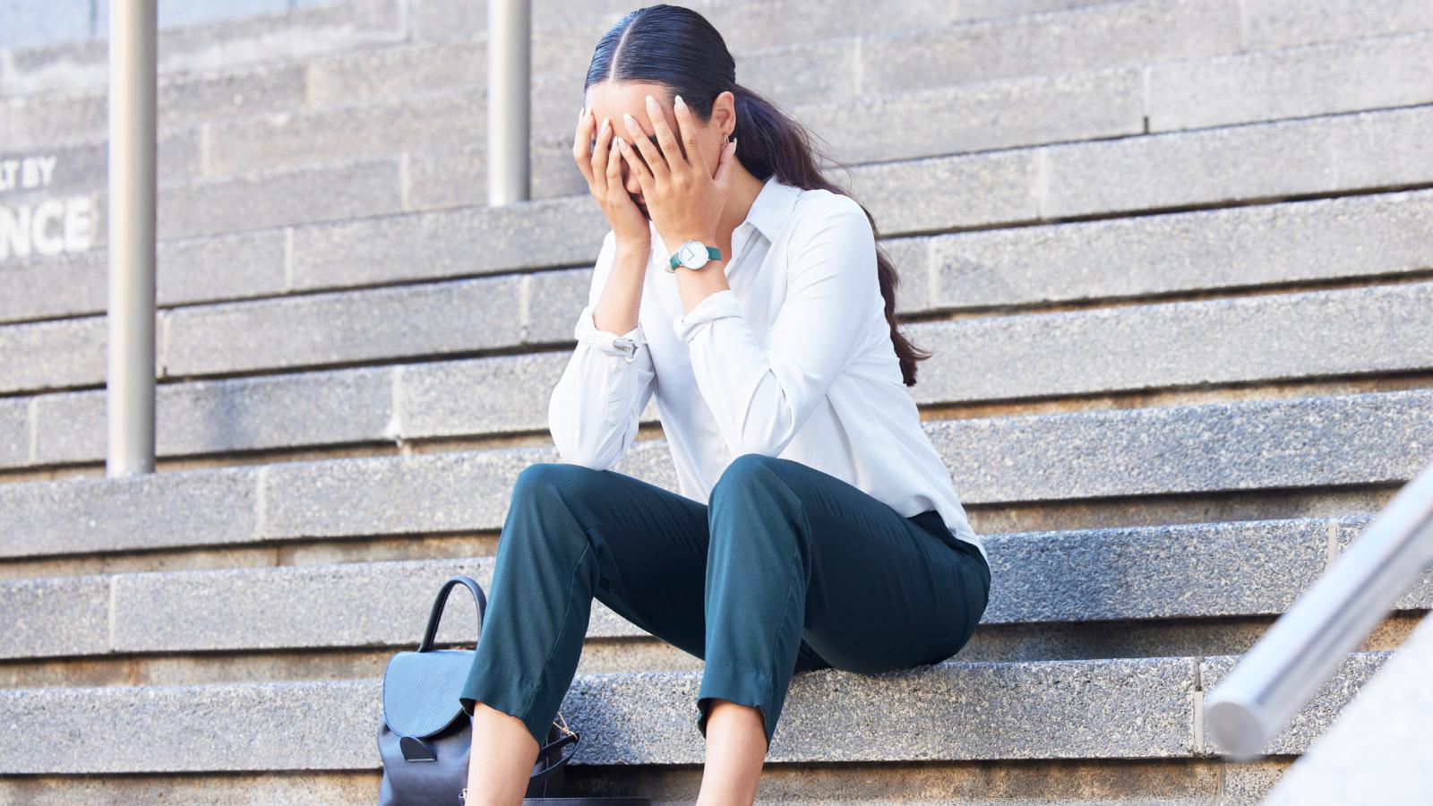 Her Father Is Terminally Ill — And Her Boss Keeps Pressuring Her to Work More Hours woman sitting on some steps