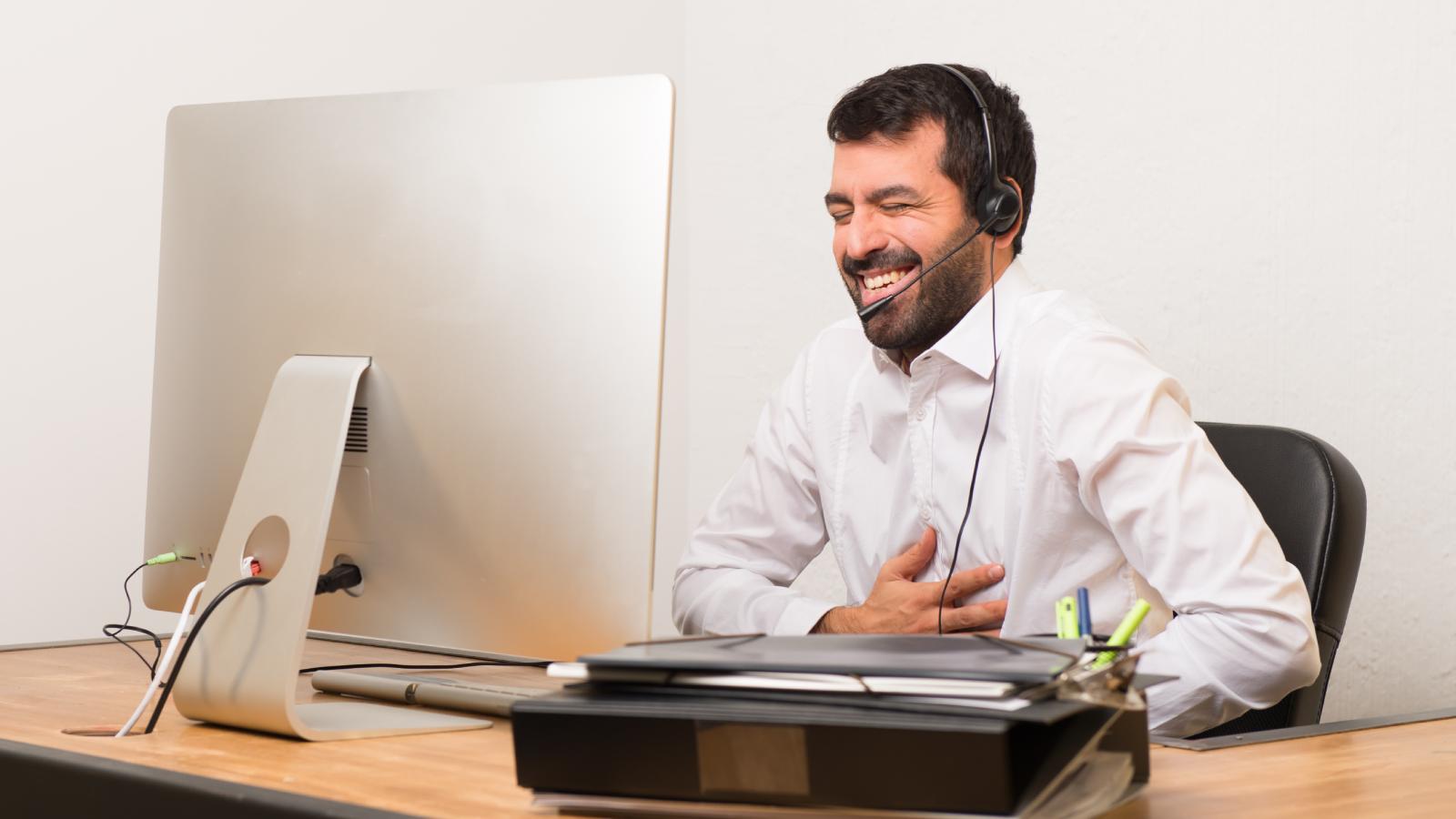 man laughing at his desk