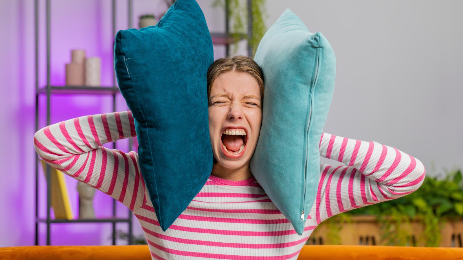 Womans Upstairs Neighbors Make Noise All Day And Night, And Shes Reaching Her Breaking Point woman with pillows over her ears