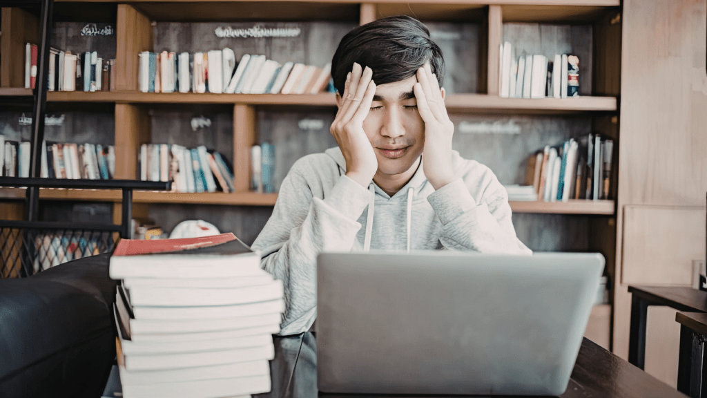 College Student Is Asked To Help Pay For Their Parents’ New Water Heater, But They Don’t Think The Expense Should Be Their Responsibility confused college student among laptops and books