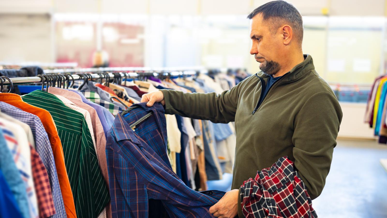 man looking at clothes in a store