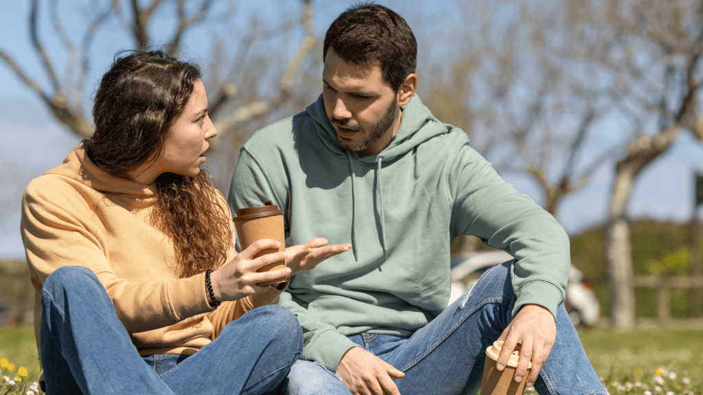 She Chose to Babysit the Neighbors Kids Over Seeing Him — He Accused Her of Not Caring About Their Relationship couple arguing outside sitting on ground with coffee cups