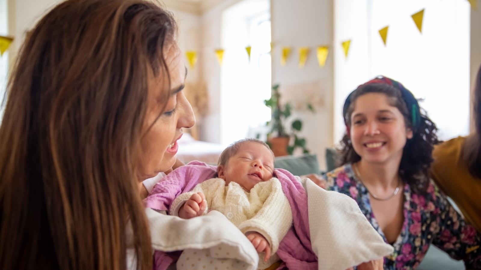 family visiting a new baby