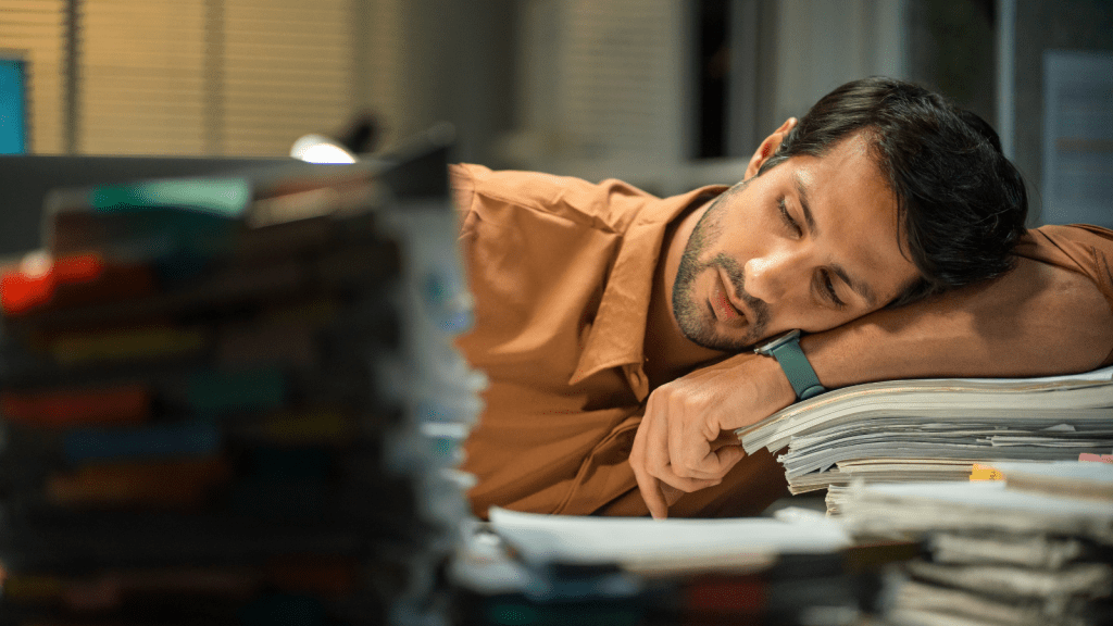 She Used Her Position To Favor Certain Workers And Wasn’t Honest About What Happened, So Management Finally Moved To Fire Her frustrated employee in office slouching over stack of papers
