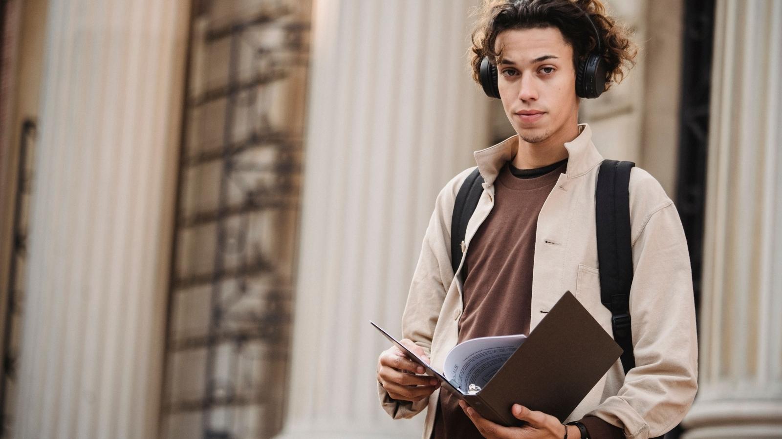 His Friend Slacked Off On A Group Project, So When He Wouldnt Redo It With Just Her, She Was Furious He Left male college student wearing headphones and holding book