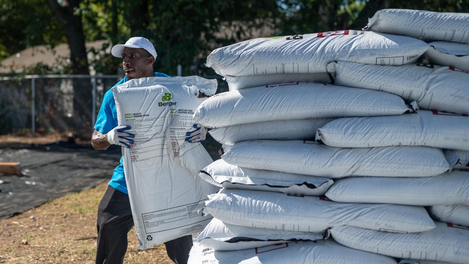 man carrying bags of mulch