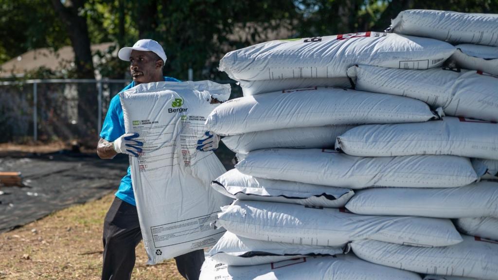 man carrying bags of mulch