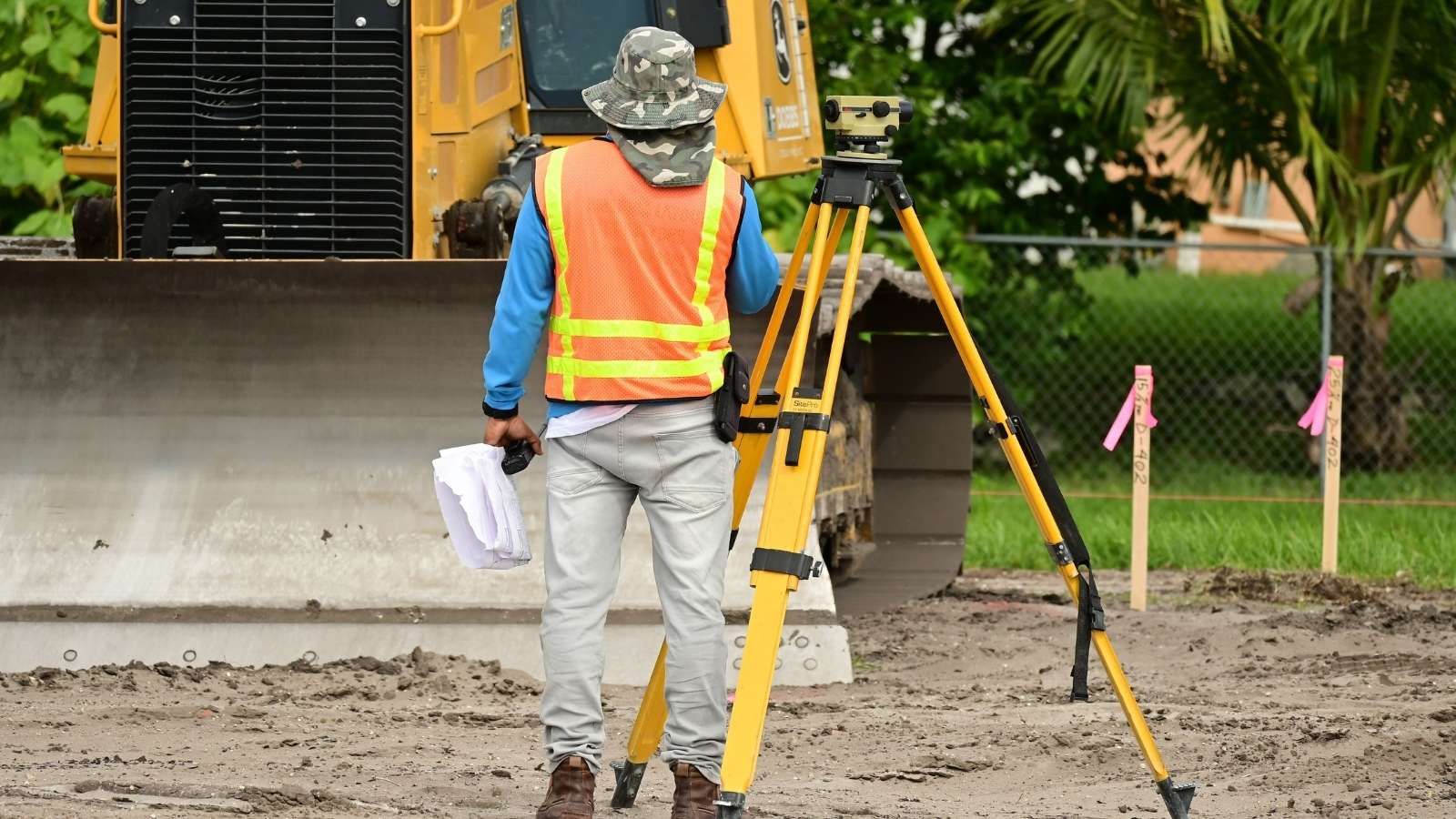 He Found a Yellow Gas Line Snaking Across His Siding—Then Filed an Emergency Municipal Code Enforcement Audit man in safety vest doing a property survey