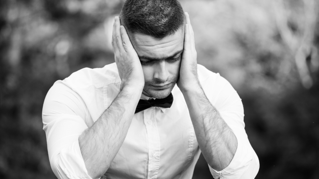 His Parents Have a Long History of Canceling on Him for His Sister — Their Latest Choice Hurts More Than Ever man in suit in black and white sad with head in hands