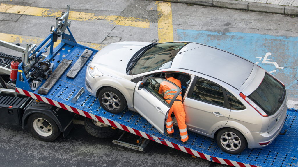 Neighbor Blocked A Homeowners Driveway With His Car, So She Finally Called A Tow Truck man in the act of towing car