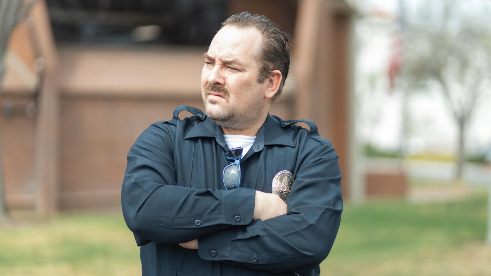 New Neighbors Called Code Enforcement on His Backyard Workshop—So He Uncovered Their Unpermitted Addition and HOA Violations man in uniform looking perplexed
