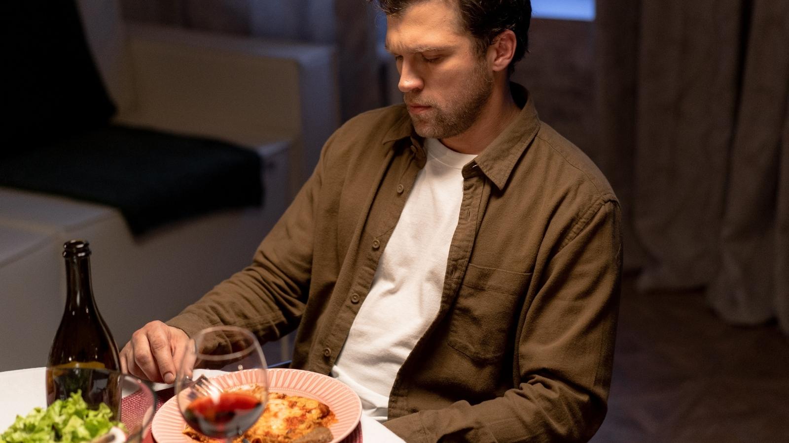 man looking upset at the dinner table