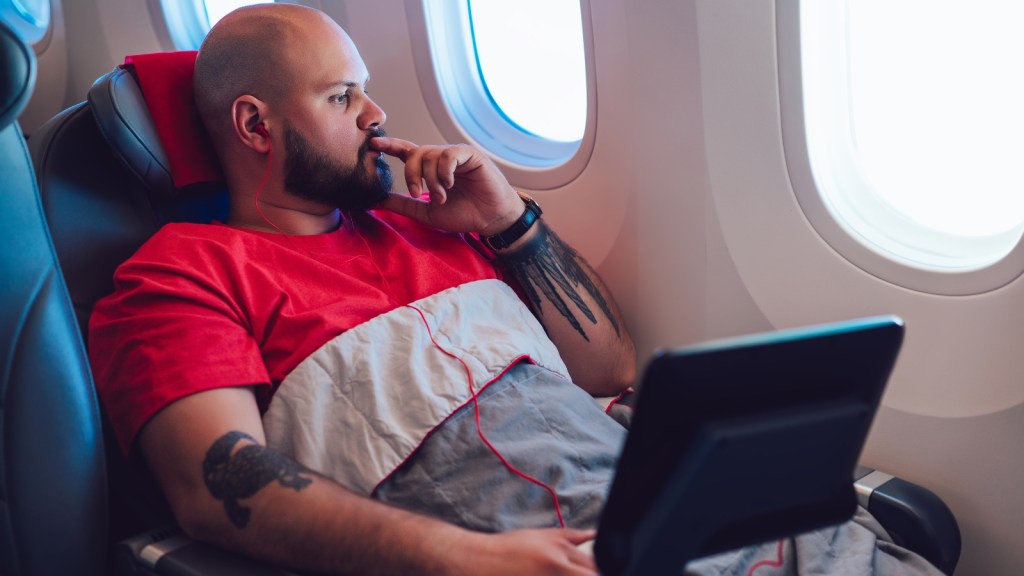 He Needed Business Class After Surgery — His Boss Said No, and It Ended Up Costing the Company Tens of Thousands More man lying in business class thinking on his flight