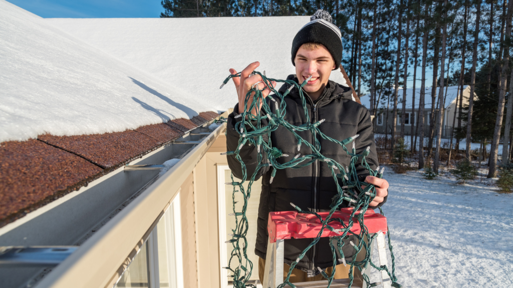 They Decorated Their Home For Christmas And Drew Complaints From The HOA, Yet The Association Has No Authority Over Their Property man putting christmas lights on house