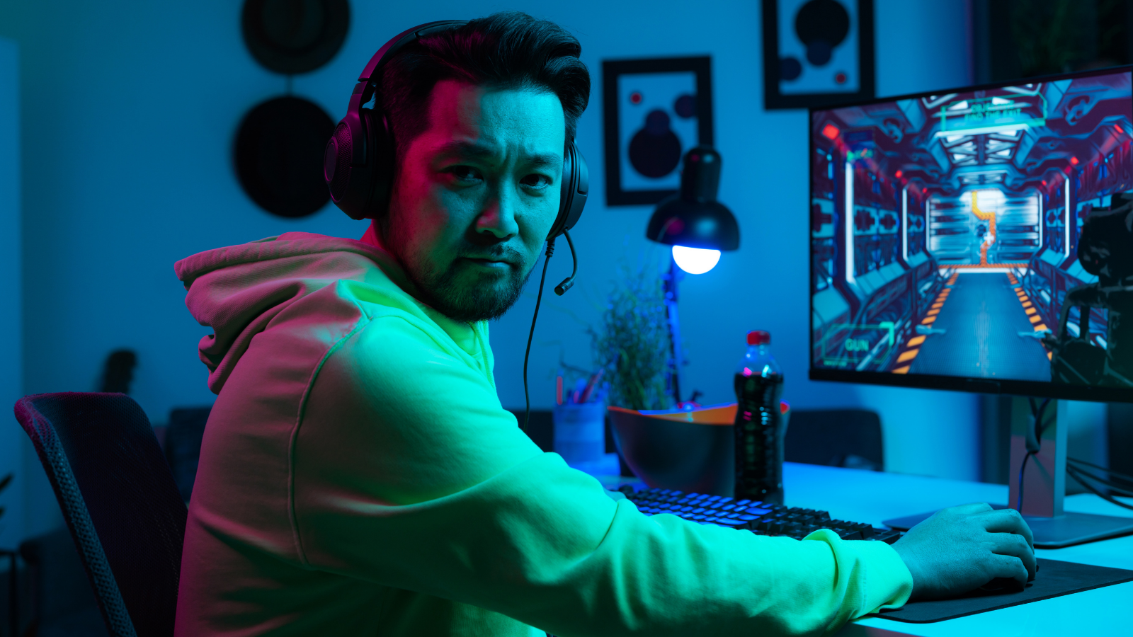 One Worker Turned A Ridiculous “Look Busy” Order Into Years Of Gaming At Work, While His Bosses Celebrated His Supposed Improvement man sitting at his computer wearing a headset and playing an online game