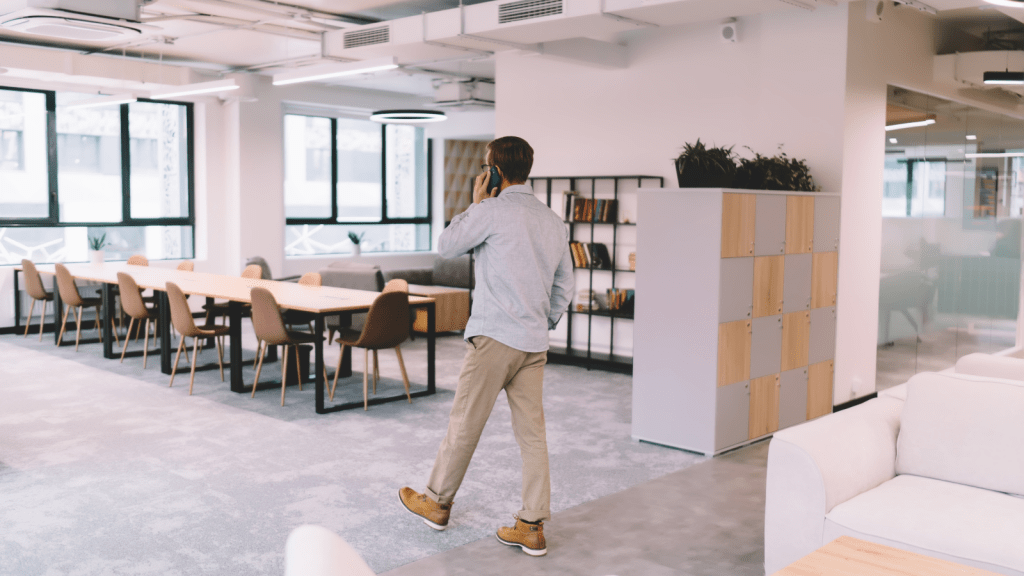 man walking around the office on the phone before clocking in