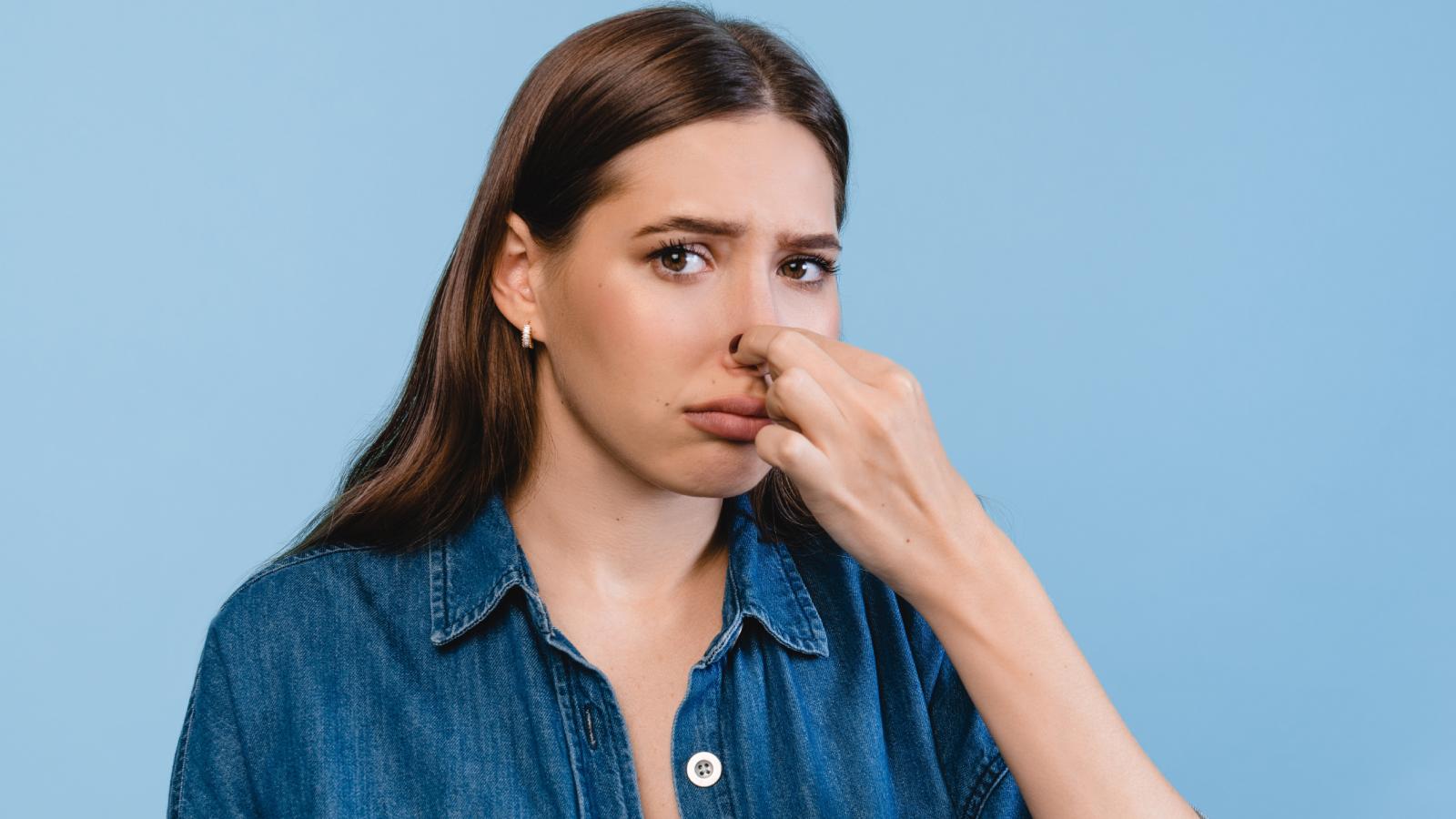 woman holding her nose