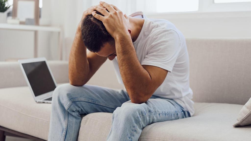 man holding his head in his hands