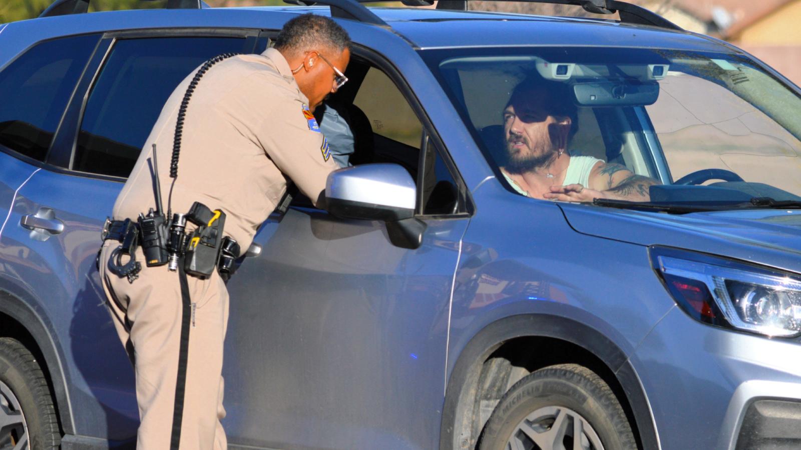 He Called the Police on His Neighbors Over Their Parenting — Years Later, Theyre Still Trashing Him Around Town cop talking to a man in a car