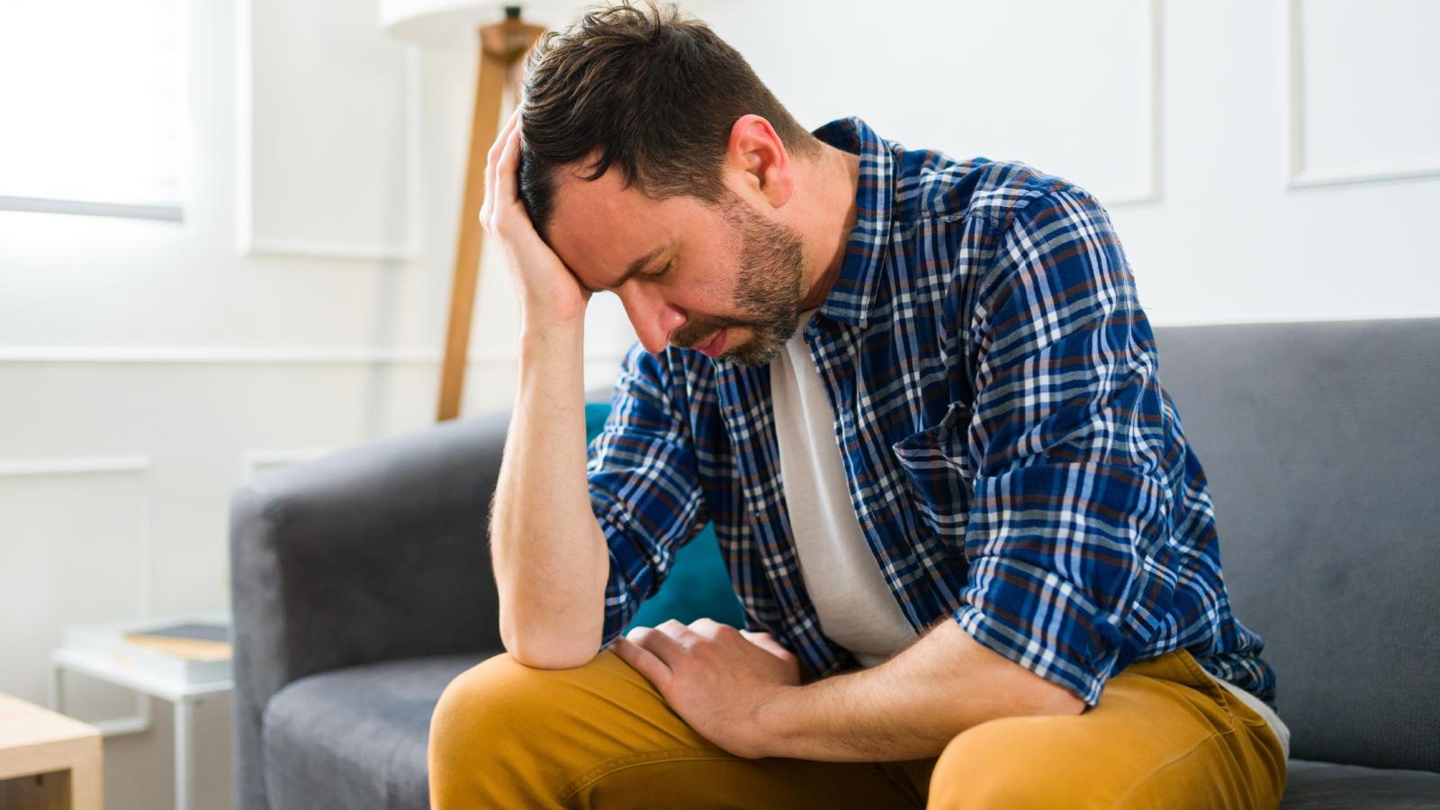 Hes Been Getting Anonymous Threats — And Still Has No Idea Whos Behind Them man stressed out on a couch