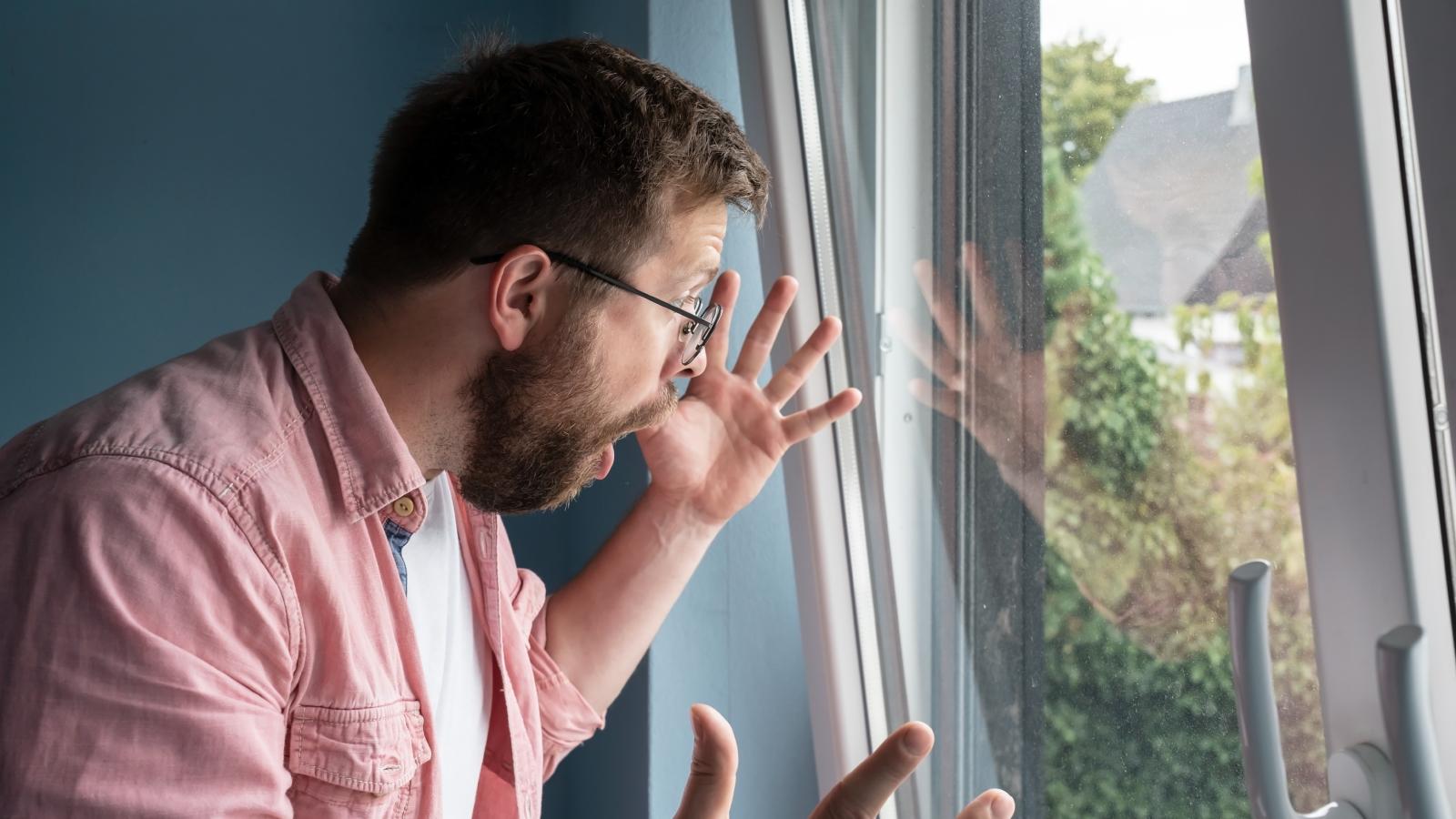 man looking out a window