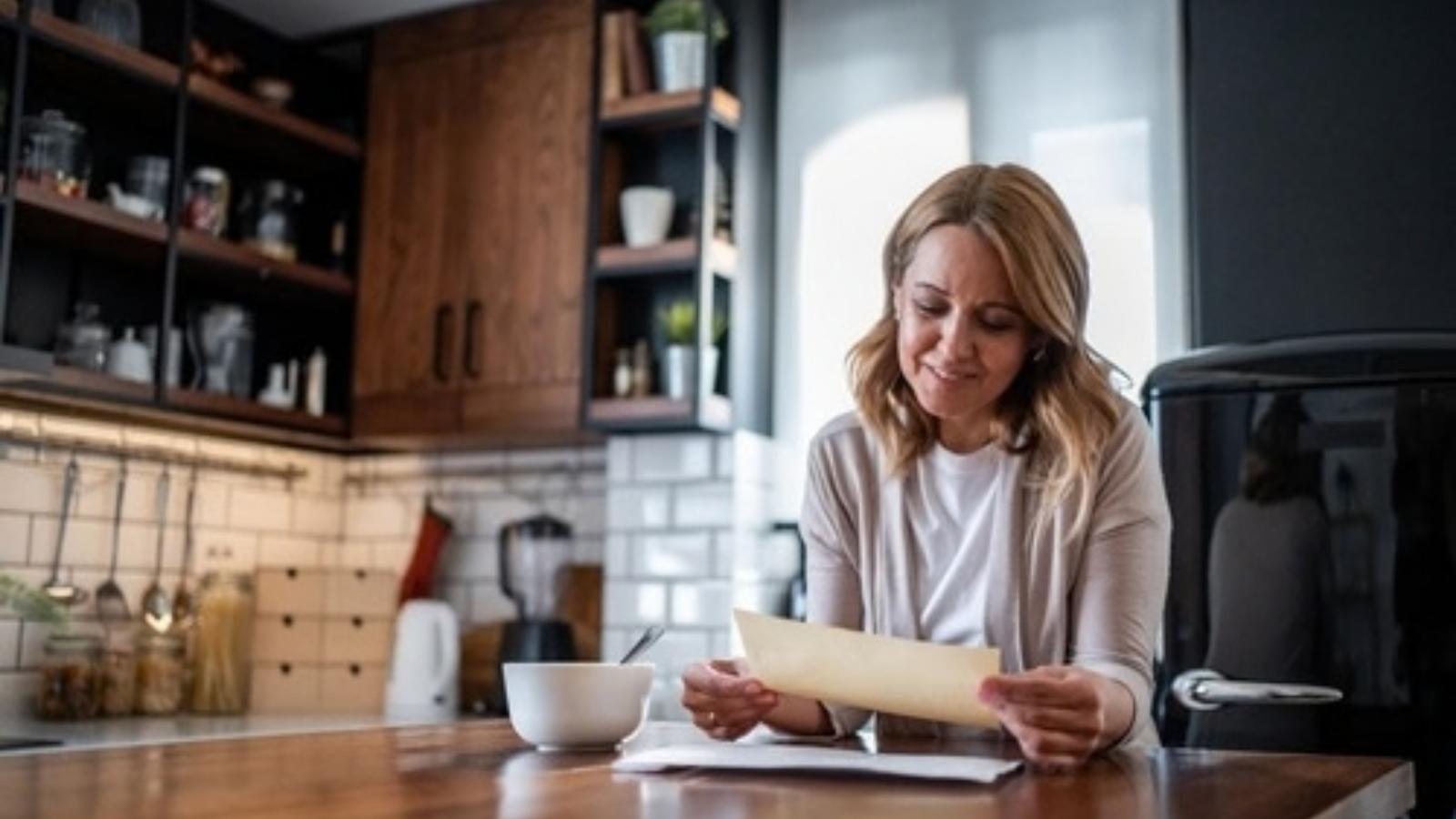 She Paid Rent to the Master Tenant in a Rental Home—Then Discovered the Neighbors Were Hostile and the Master Tenant Was Running an Illegal Sublet Scam Woman opening mail